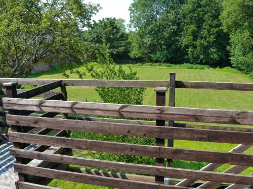 a wooden fence with a field behind it at The Wherry Arch in Neatishead