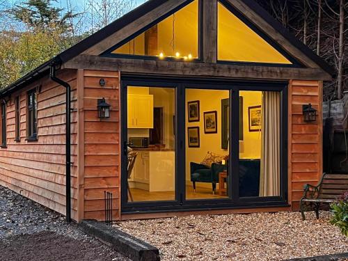 a tiny house with a large glass door at South Downs Lodge in Soberton