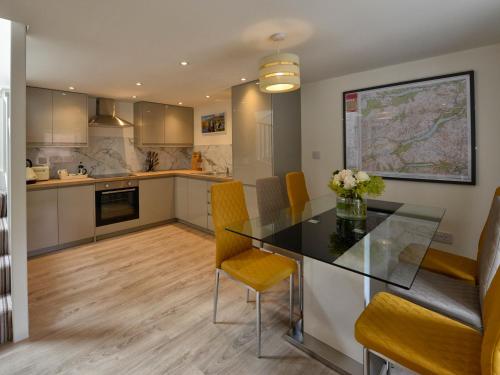 a kitchen and dining room with a glass table and chairs at Bonnie Cottage - Uk40057 in Aberfeldy