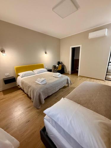 a bedroom with two beds and a yellow headboard at Sottovento B&B in Trani
