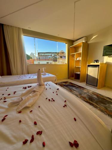 a bedroom with a bed with red rose petals on it at Tua Pyramids View in Cairo