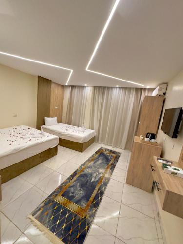 a hotel room with two beds and a television at Tua Pyramids View in Cairo