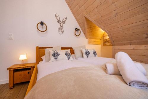 a bedroom with two beds in a attic at Rogata Chata Tatra View & Jacuzzi in Kościelisko