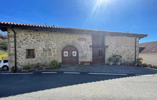 a building with a car parked in front of it at Hermoso Caserío Navarra. (Madoz) in Madoz