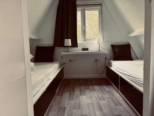 a small room with two beds and a window at Chalet AchiLou in Durbuy