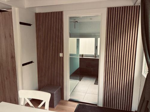 a bathroom with a glass door leading to a shower at Chalet AchiLou in Durbuy