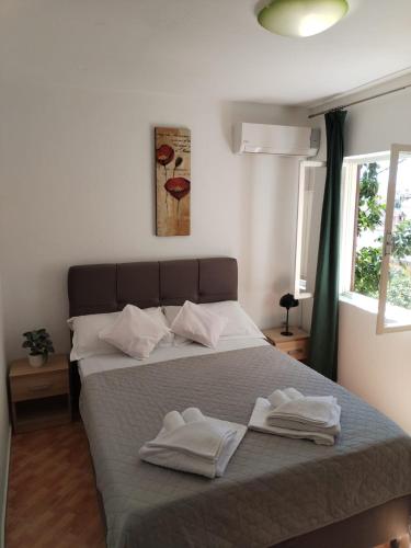 a bedroom with a bed with two towels on it at Apartments Knežić in Igrane