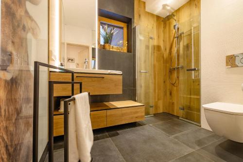 a bathroom with a shower and a sink and a toilet at Rogata Chata Tatra View & Jacuzzi in Kościelisko