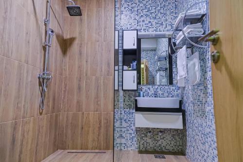 ein Badezimmer mit Dusche, Waschbecken und Spiegel in der Unterkunft Hotel Gold in Pljevlja