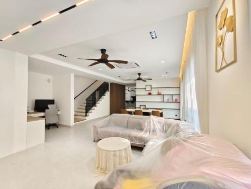 a living room with a bed and a ceiling fan at Mallow Semi-D homestay in Rawang
