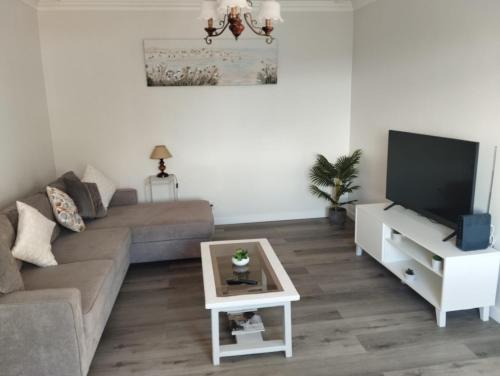 a living room with a couch and a tv at Quinta do Araújo - GuestHouses in Câmara de Lobos