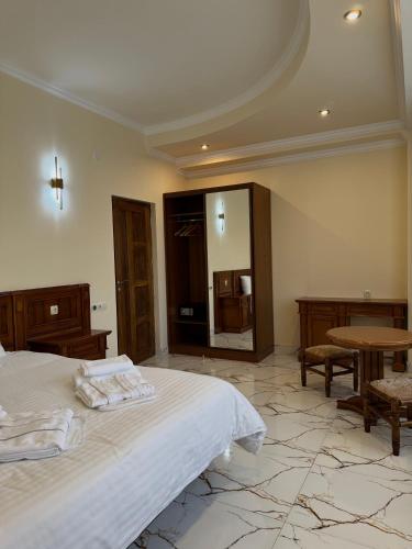a bedroom with a bed and a table and a mirror at Lalaner Hotel in Sisian