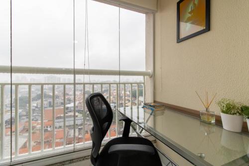 a office with a glass desk and a chair in front of a window at Lovely Studio - GRU 1613 in Guarulhos