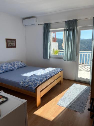 a bedroom with a bed and a large window at Guest House Life in Neum