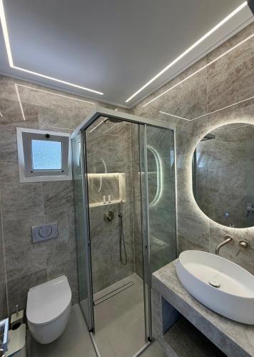 a bathroom with a shower and a toilet and a sink at Aliki Studios in Parga