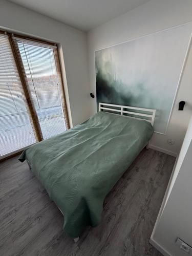 a bedroom with a bed and a large window at Wydmowa Ostoja in Żarnowska