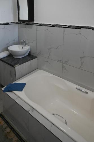 a bathroom with a bath tub and a sink at Lagrande CBD in Benoni