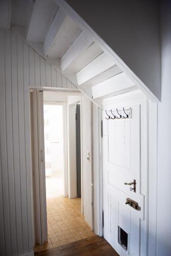 a hallway with a white door and a staircase at Pim's in Steffeln