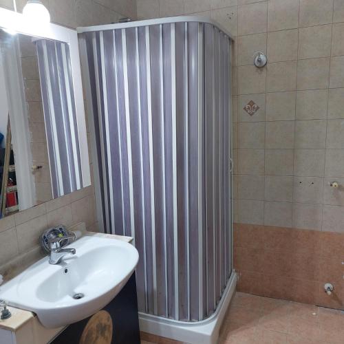 a bathroom with a shower with a sink and a mirror at Chiaro di Luna in Crispiano