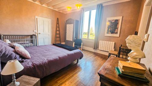 a bedroom with a bed and a table and a window at L'Aube du Lac in Drosnay