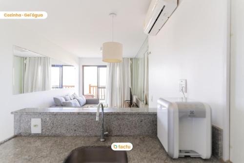 a kitchen with a sink and a living room at Equipped studio with sea view VG Sun Cumbuco in Paracumbuca