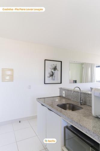 a white kitchen with a sink and a mirror at Equipped studio with sea view VG Sun Cumbuco in Paracumbuca
