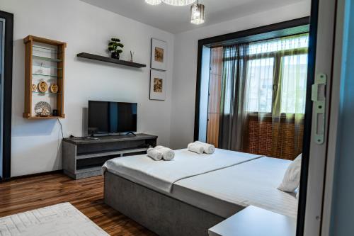 a bedroom with a large bed and a television at Apartament Deea in Orşova