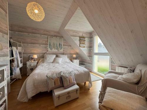 a bedroom with a bed and a chair and a window at Au Bois Dormant in Monterblanc