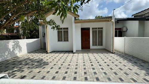 a white house with a door and a fence at Journy B Holiday Inn Ekala in Ekala