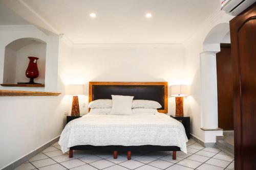 a bedroom with a bed with a white bedspread at Hotel Boutique Plaza Doradas in San José del Cabo