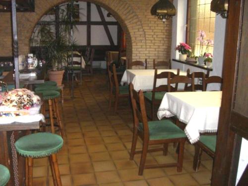 uma sala de jantar com mesas e cadeiras num restaurante em Hotel Alte Münze em Gifhorn