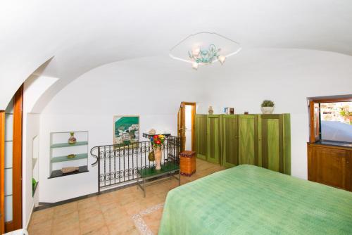 1 dormitorio con cama verde y techo en Casa Valentina, en Positano