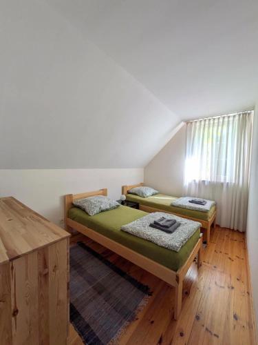 a bedroom with two beds and a window at Gospodarstwo agroturystyczne nad jeziorem wśród lasów in Lipnica
