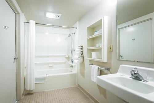 y baño blanco con lavabo y ducha. en Budget Motel en Burley