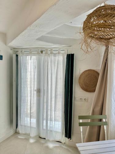 a room with a window with curtains and a chair at Loft en Binibeca in Binibeca