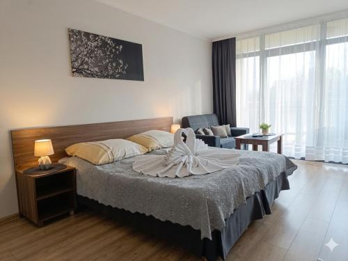 a hotel room with a bed and a chair at Umberto Apartamenty Dwupoziomowe Dąbki in Dąbki