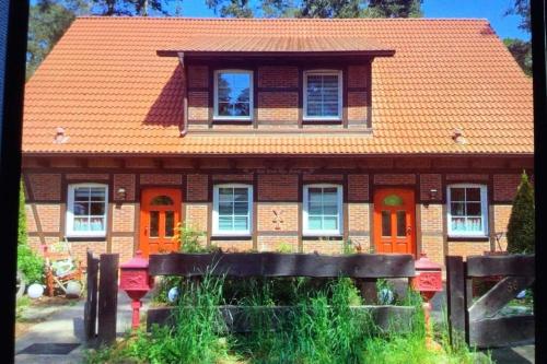 a house with an orange roof and orange doors at Welsh House in Siedlung Schönwalde
