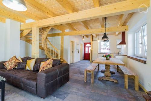 a living room with a brown couch and a wooden ceiling at Welsh House in Siedlung Schönwalde