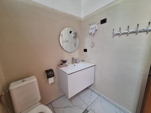 a bathroom with a toilet and a sink and a mirror at Mermaid Hotel Vlore in Vlorë
