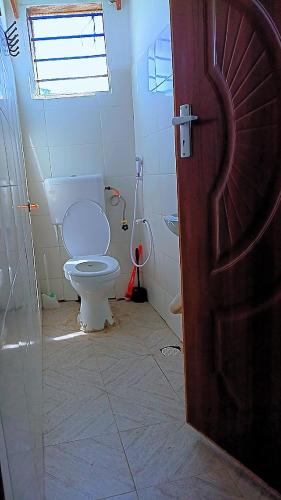 a bathroom with a toilet and a window at Reign homes in Watamu