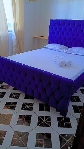 a purple bed sitting on top of a room at Reign homes in Watamu