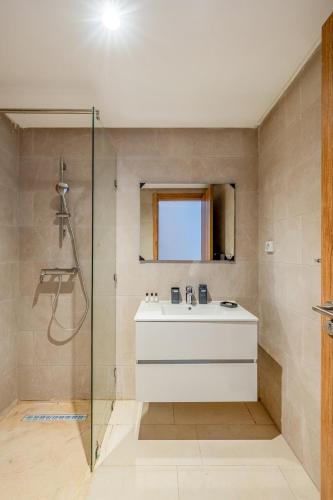 a bathroom with a white sink and a shower at Noria Golf Apartment in Marrakesh