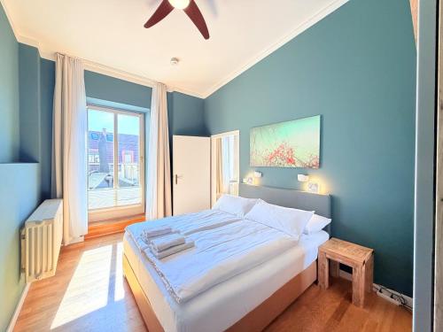 a bedroom with a large bed with a blue wall at Amaroo - Serviced Apartments "Branden" in Potsdam