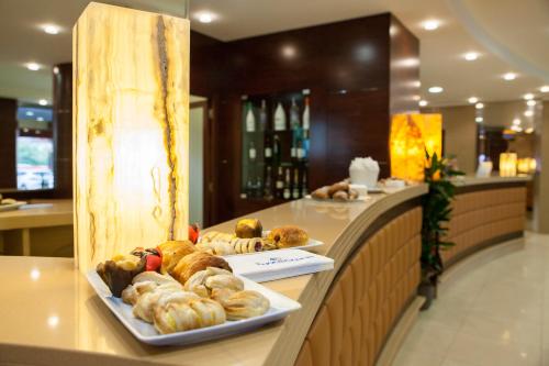 a bakery with two plates of pastries on a counter at BV President Hotel in Rende