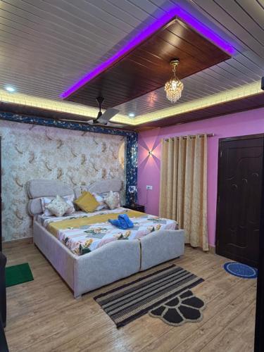 a bedroom with a large bed with purple lighting at Dev Murti Eco Resort in Chālsa Mahābāri