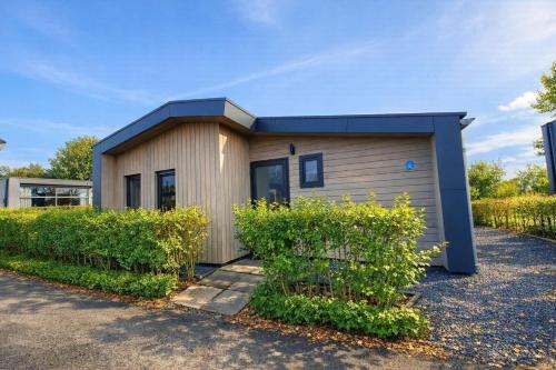 a small house with a blue roof at Torenvalk 32 in Hulshorst