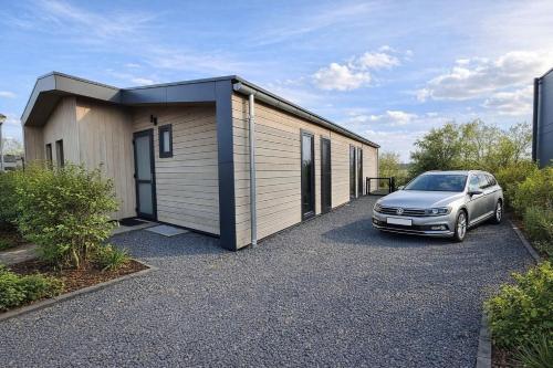 a car parked in front of a tiny house at Torenvalk 32 in Hulshorst