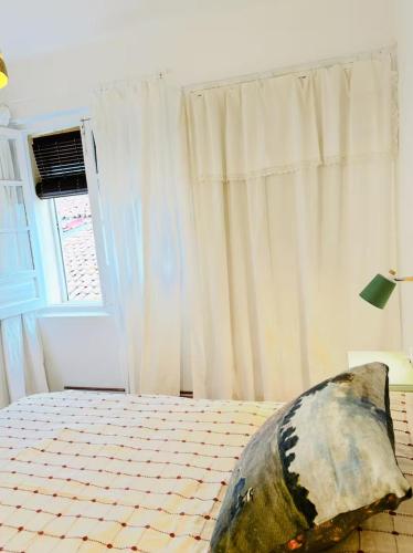 a bedroom with a bed and a window at Casa Claudio Palomar in Palomar de Arroyos
