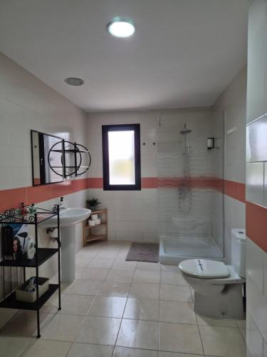 a bathroom with a tub and a toilet and a sink at Sunhouse in Playa Honda