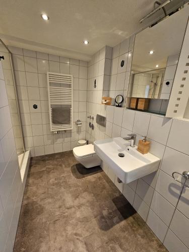 a bathroom with a sink and a toilet at Ferienwohnung Alina in Rust